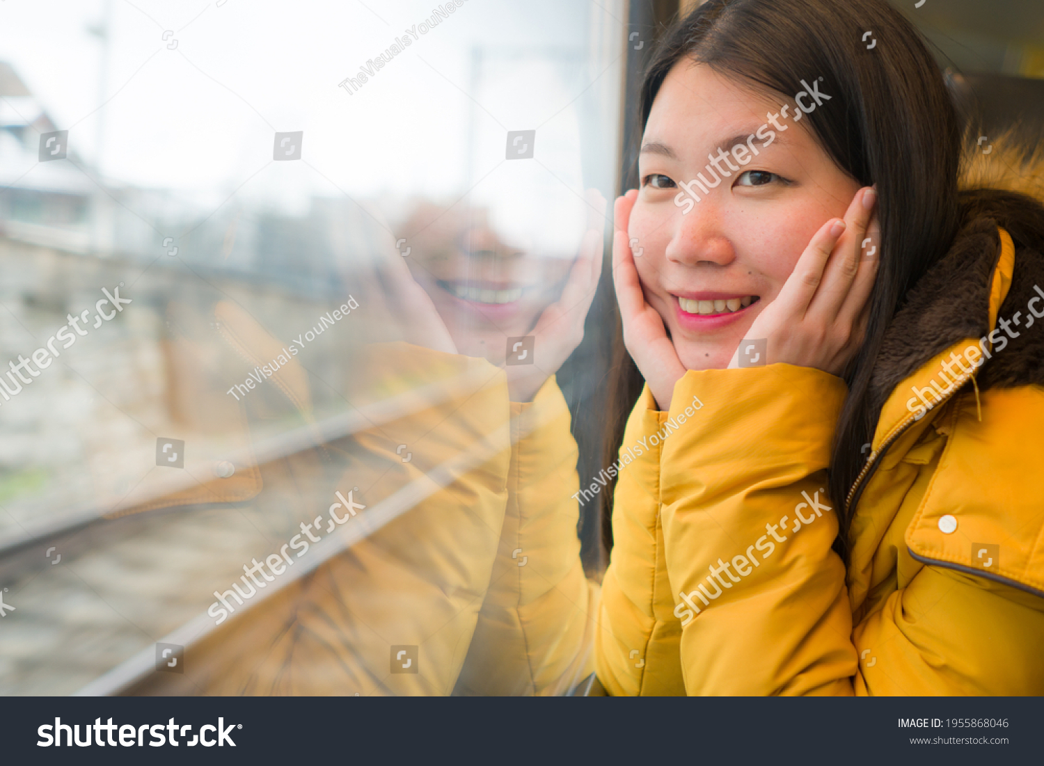 young beautiful and happy Asian Chinese woman sitting on train looking out to window enjoying holidays travel in Europe smiling thoughtful and sweet