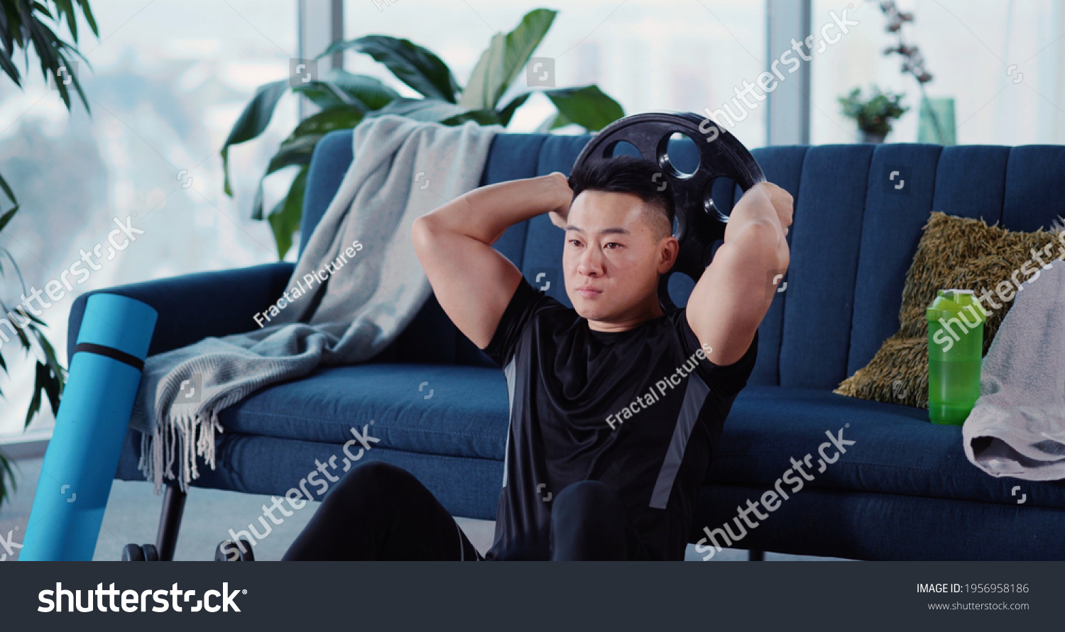 Handsome Strong Asian Young Man Engaged in Heavy Sports Bodybuilding Lifting Barbell Disc Practicing Strength Endurance Working out in Living Room.