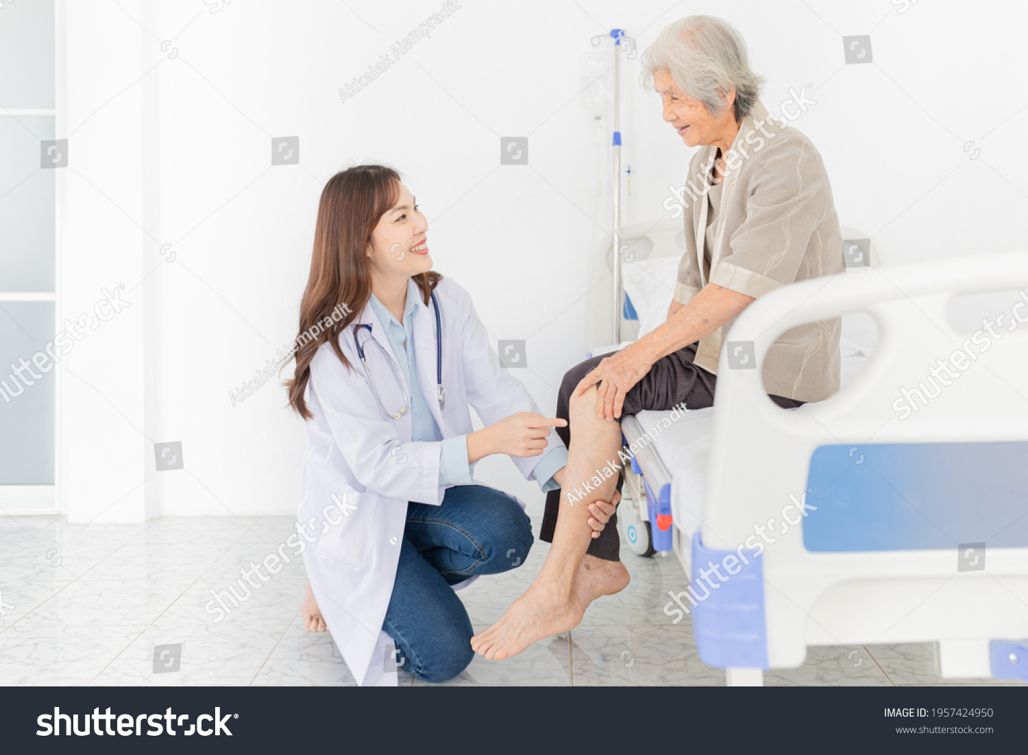 smart asian female doctor holding leg of old stroke patient in hospital elderly rehabilitation clinic they training to rehab muscle