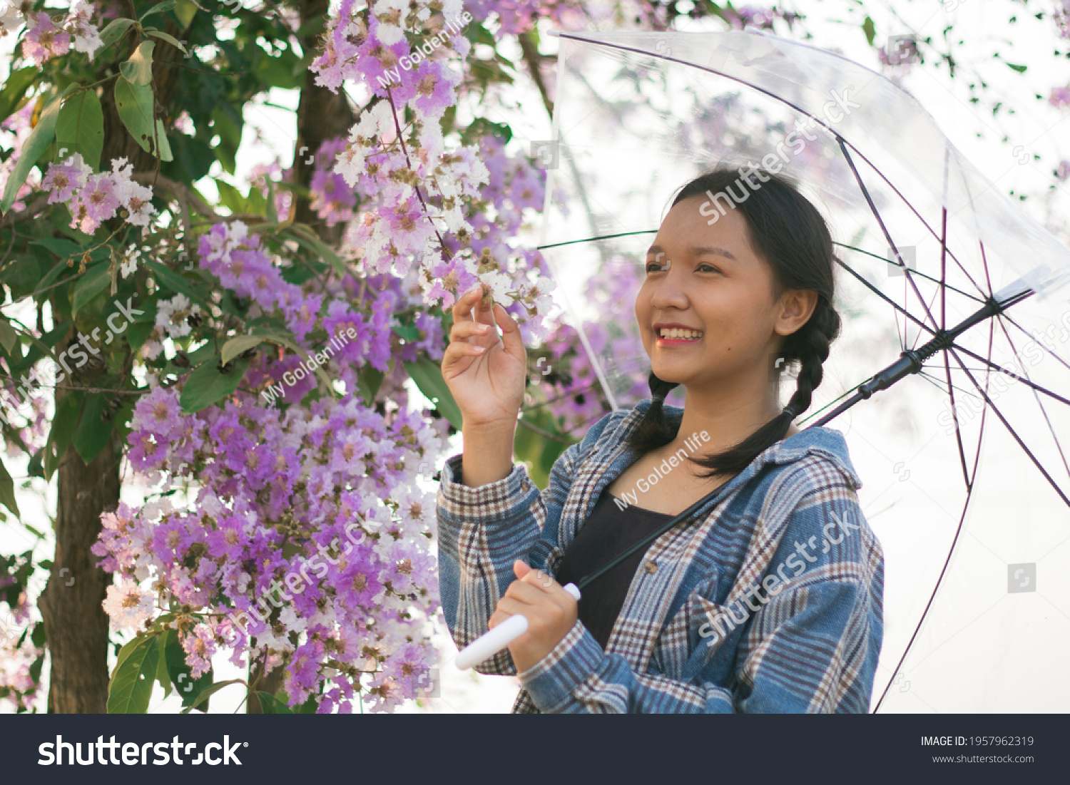 Asian young girl hold umbrella with purple flower.
