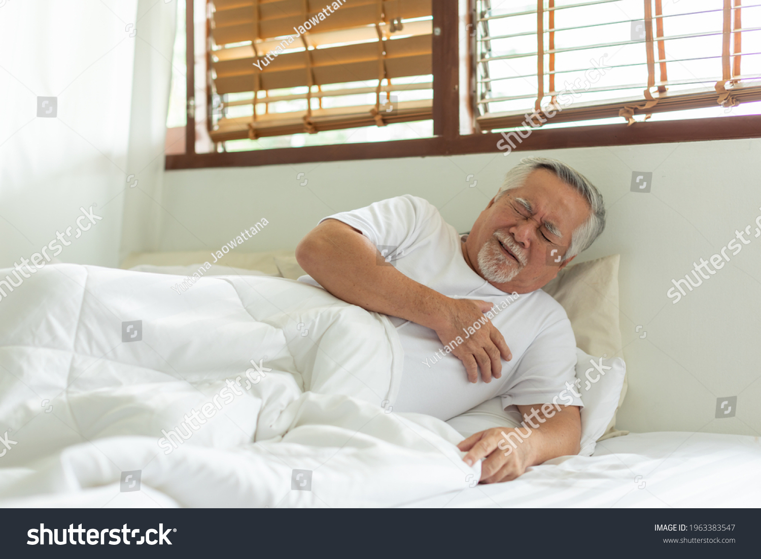 Emergency of Asian Elderly senior man sudden heart attack so pain clutching on chest and illness with diabetes symptoms on bed alone and need Urgently help Elderly care concept