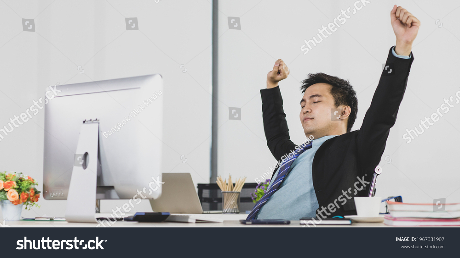 Asian adult businessman is office people very handsome and smart wearing black suit sleep and close his eye do relaxing feel comfortable stretching hands.
