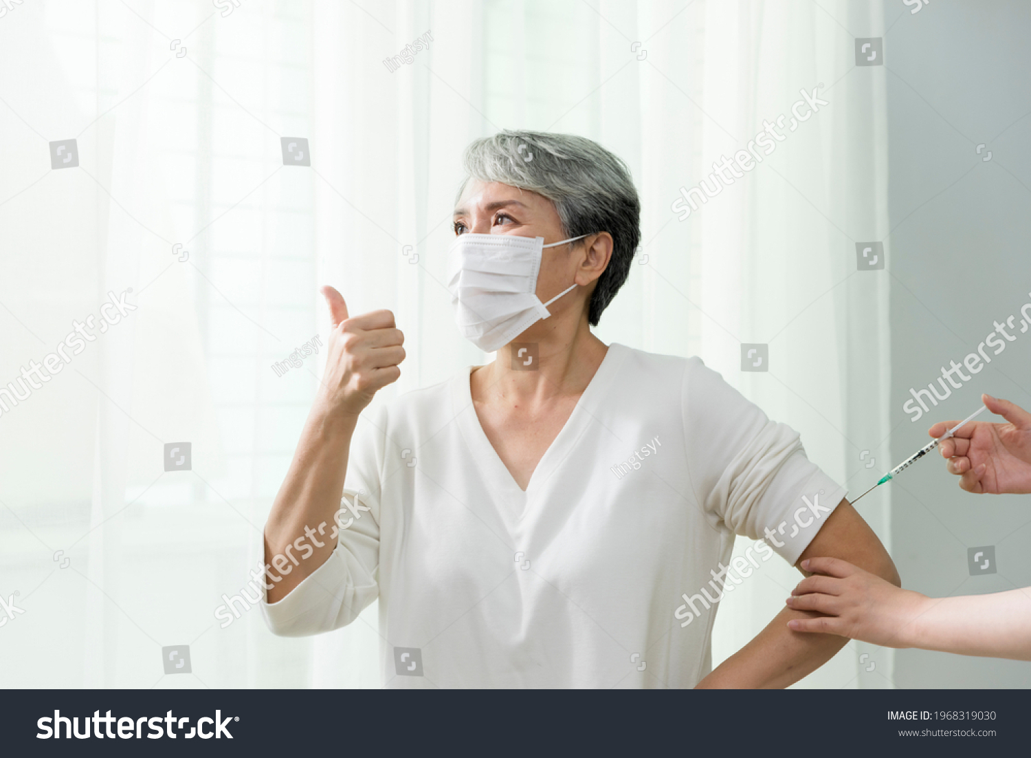 
Woman with gray hair bravely accepts injection