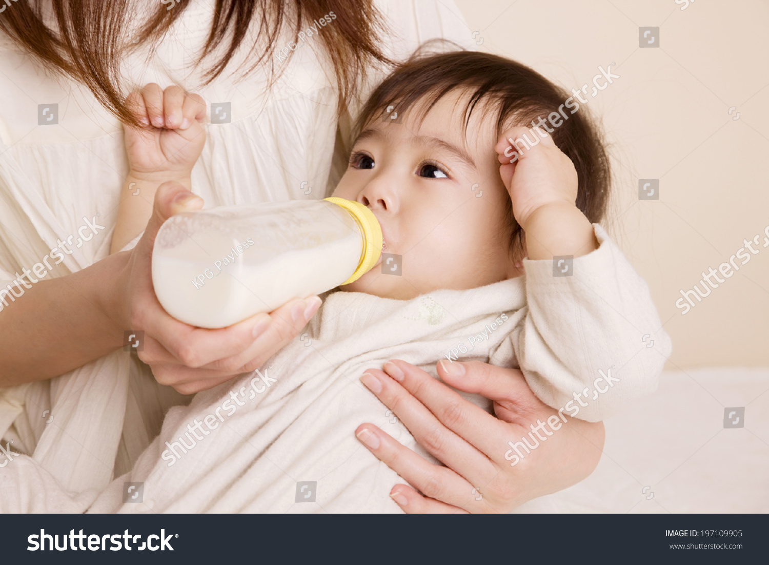 Baby Drinking Milk While Being Embraced By Mother