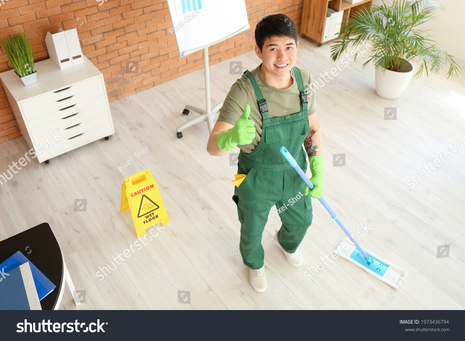 Portrait of male Asian janitor in office