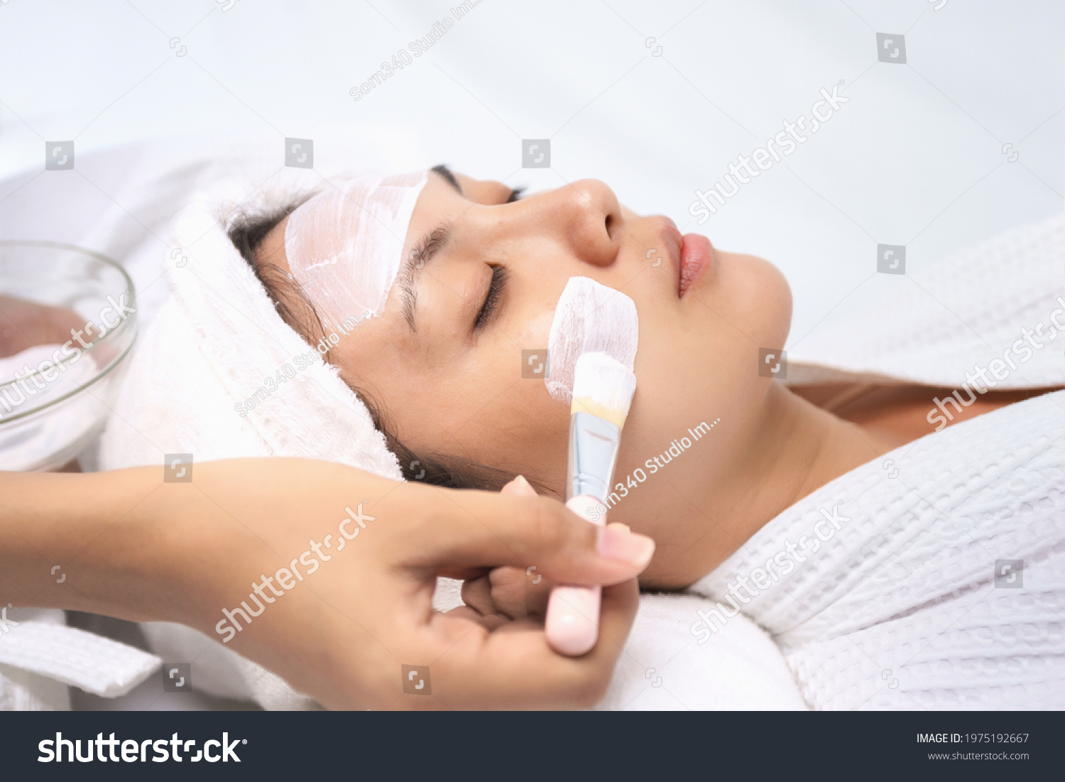 Asian young women lying relax using mask brush moisturize their skin making skin hydrated helps with homemade apply face mask. Leisure activity at home.