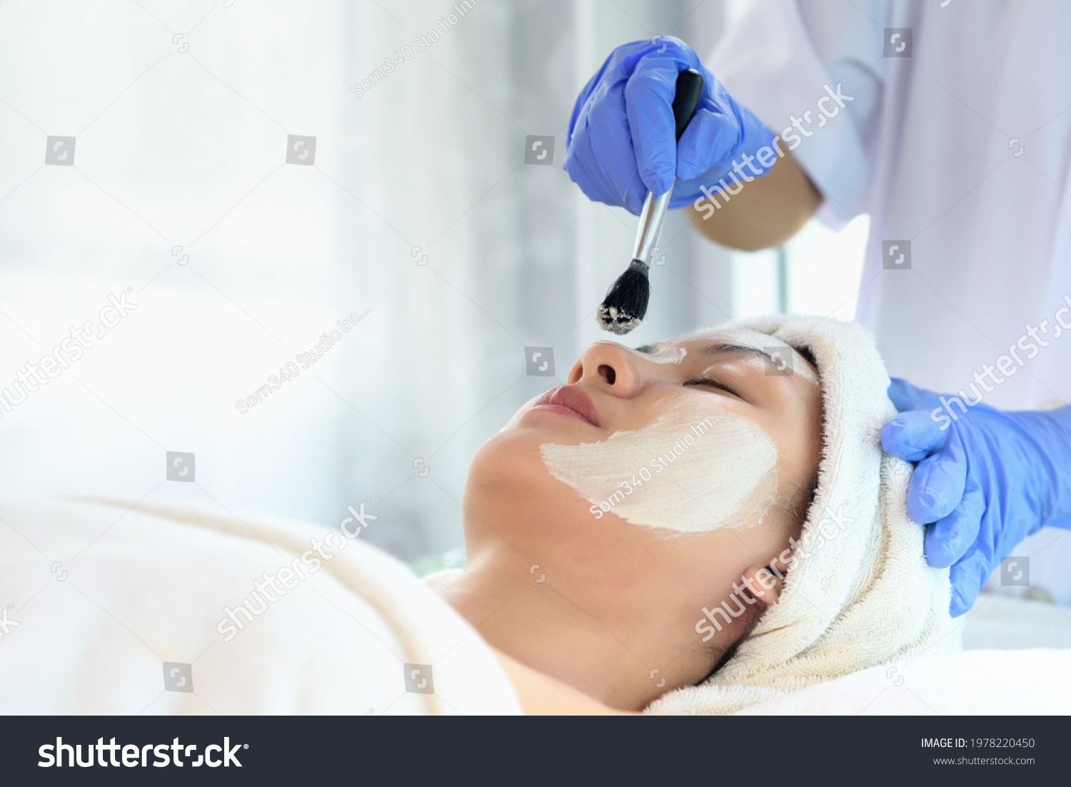 Young Asian Women getting facial care Facial masks and spa beauty treatment for soft smooth silky skin by beauticians at spa salon. Beauty skincare concept