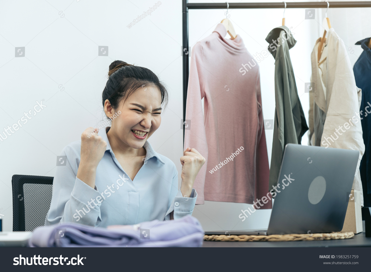 Young asian entrepreneurs are excited about hitting today's clothing sales target.