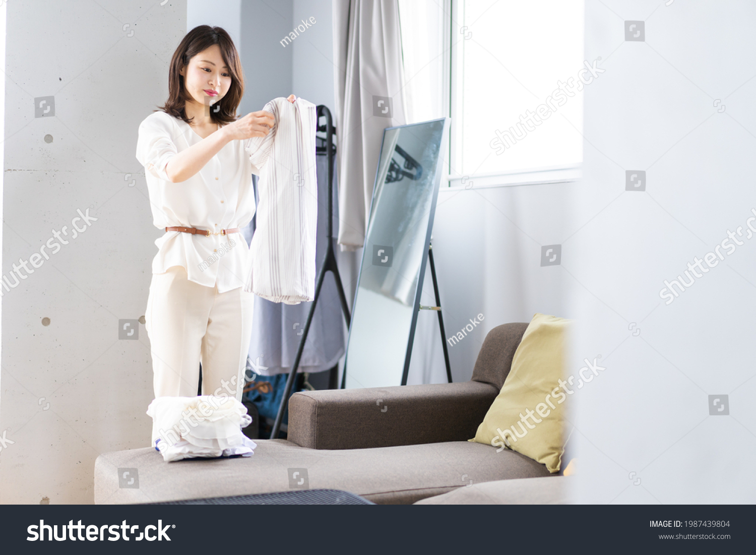 A young woman folding laundry at home