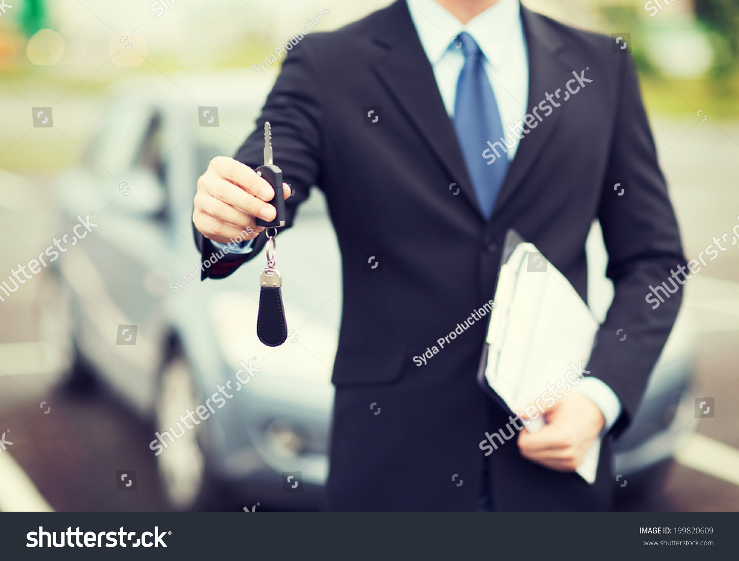 transportation and ownership concept - man with car key outside