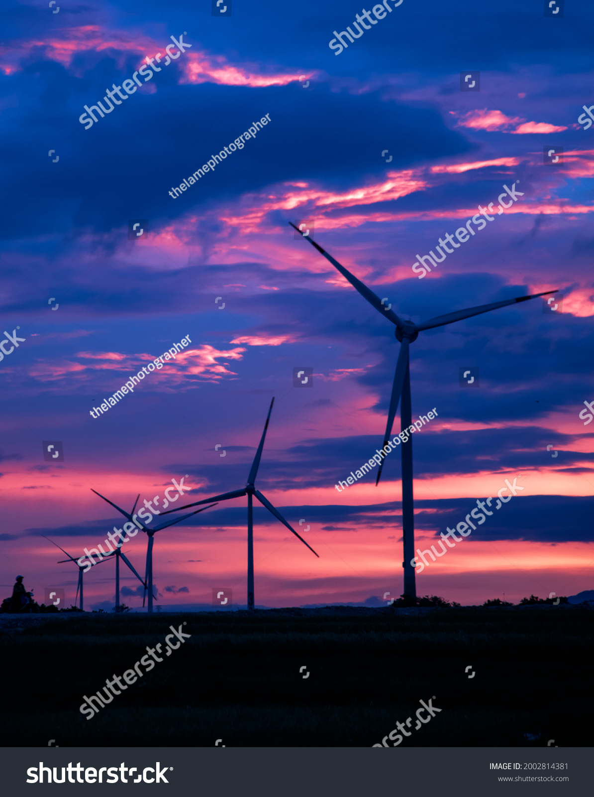 aerialdroneviewofwindmillenergyfarmatsunsetlandscapewithturbine