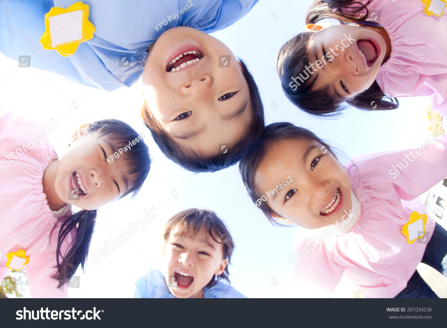 Five kindergarten children laughing in a circle