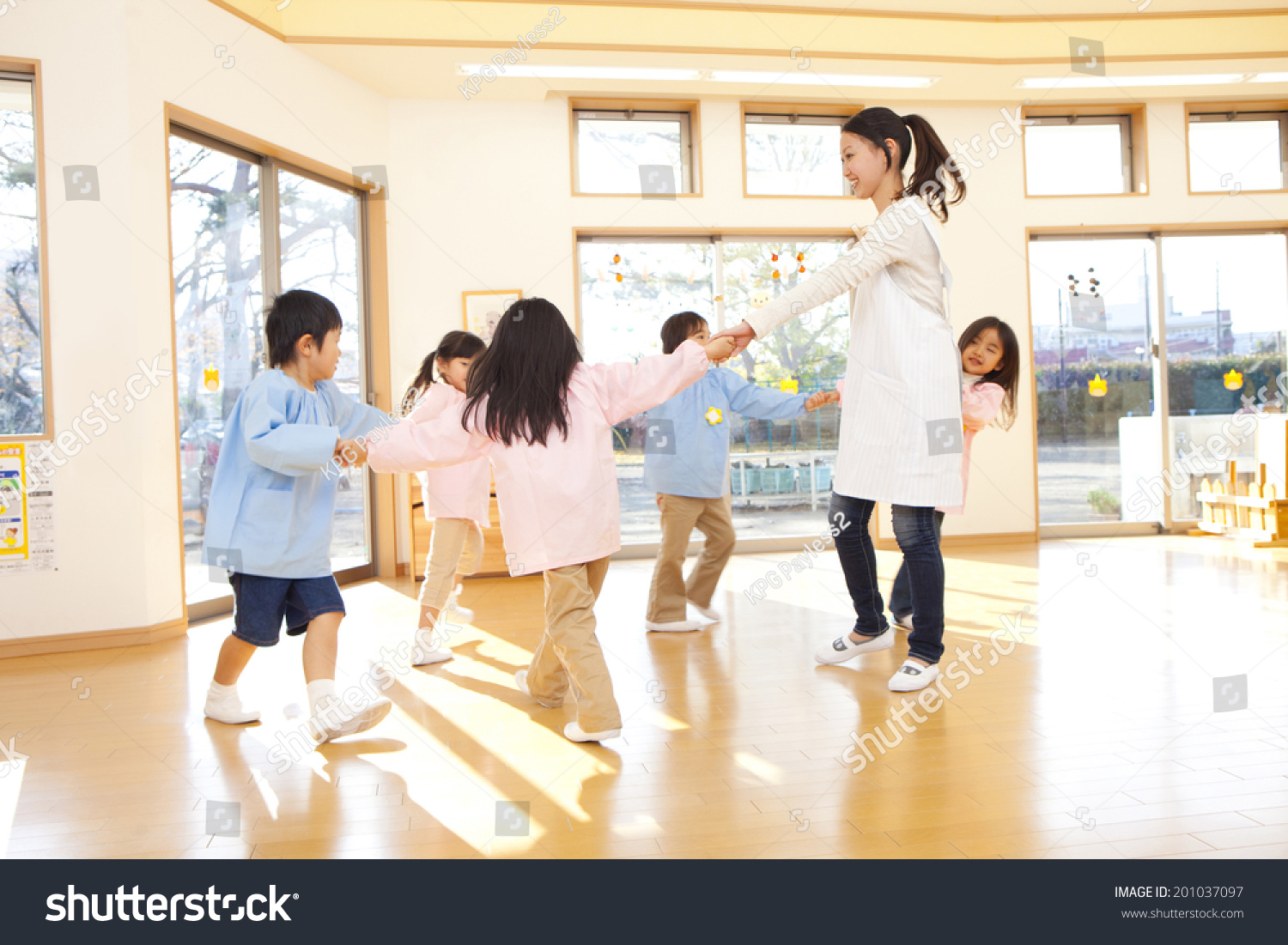 Kindergarteners and kindergarten teachers dancing in a circle