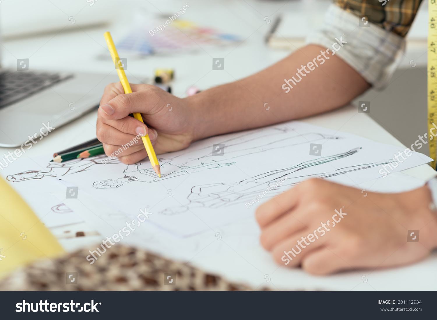 Close-up of designer drawing a fashion sketch