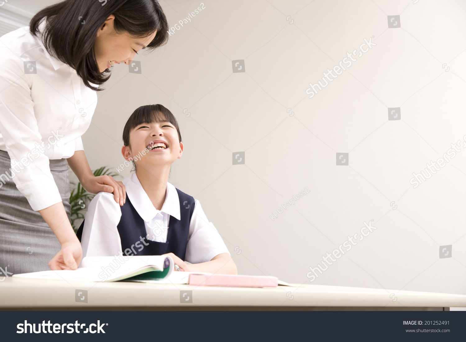 A middle school girl learning from a teacher at an institute