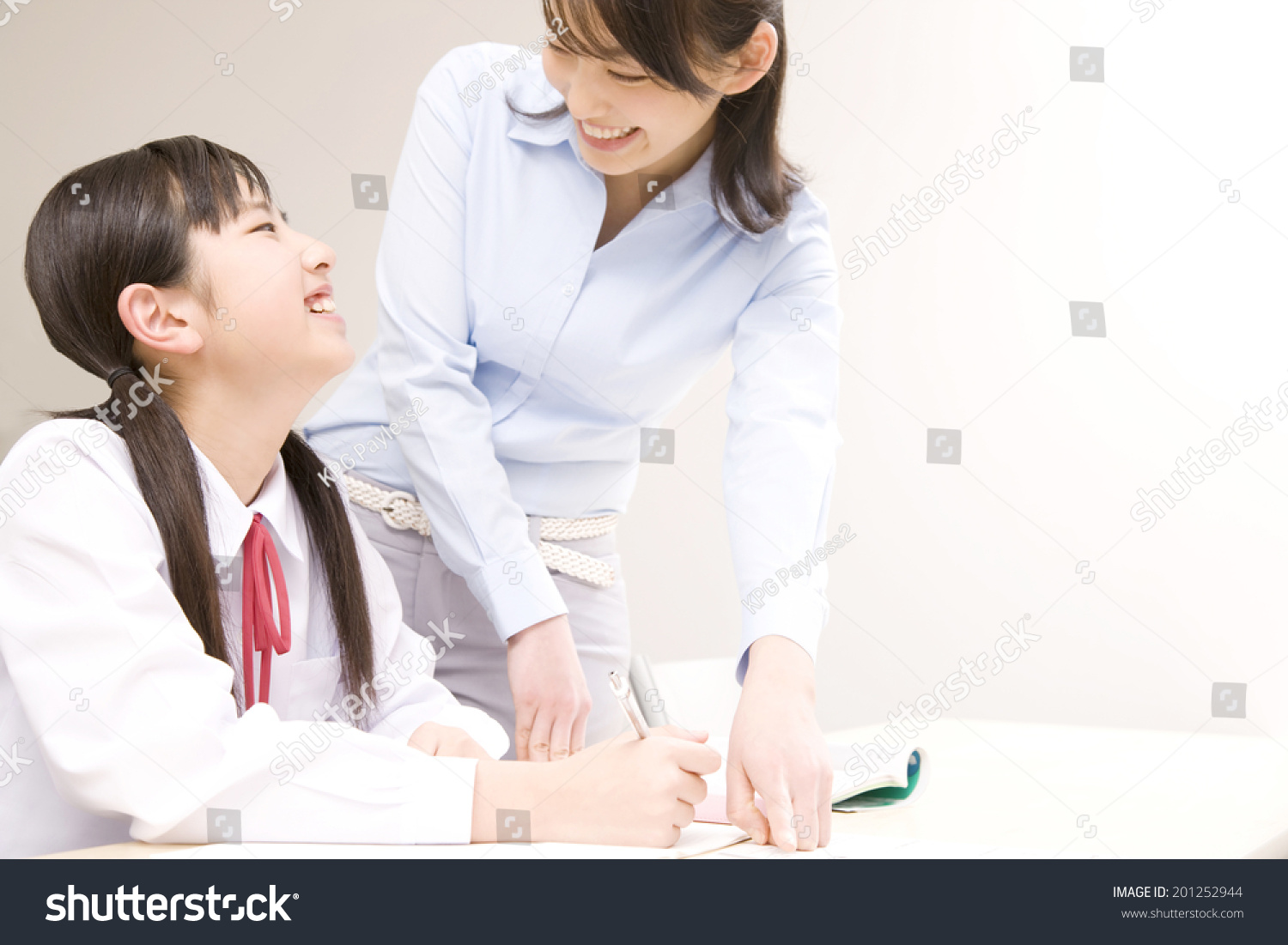 A middle school girl learning from a teacher at an institute