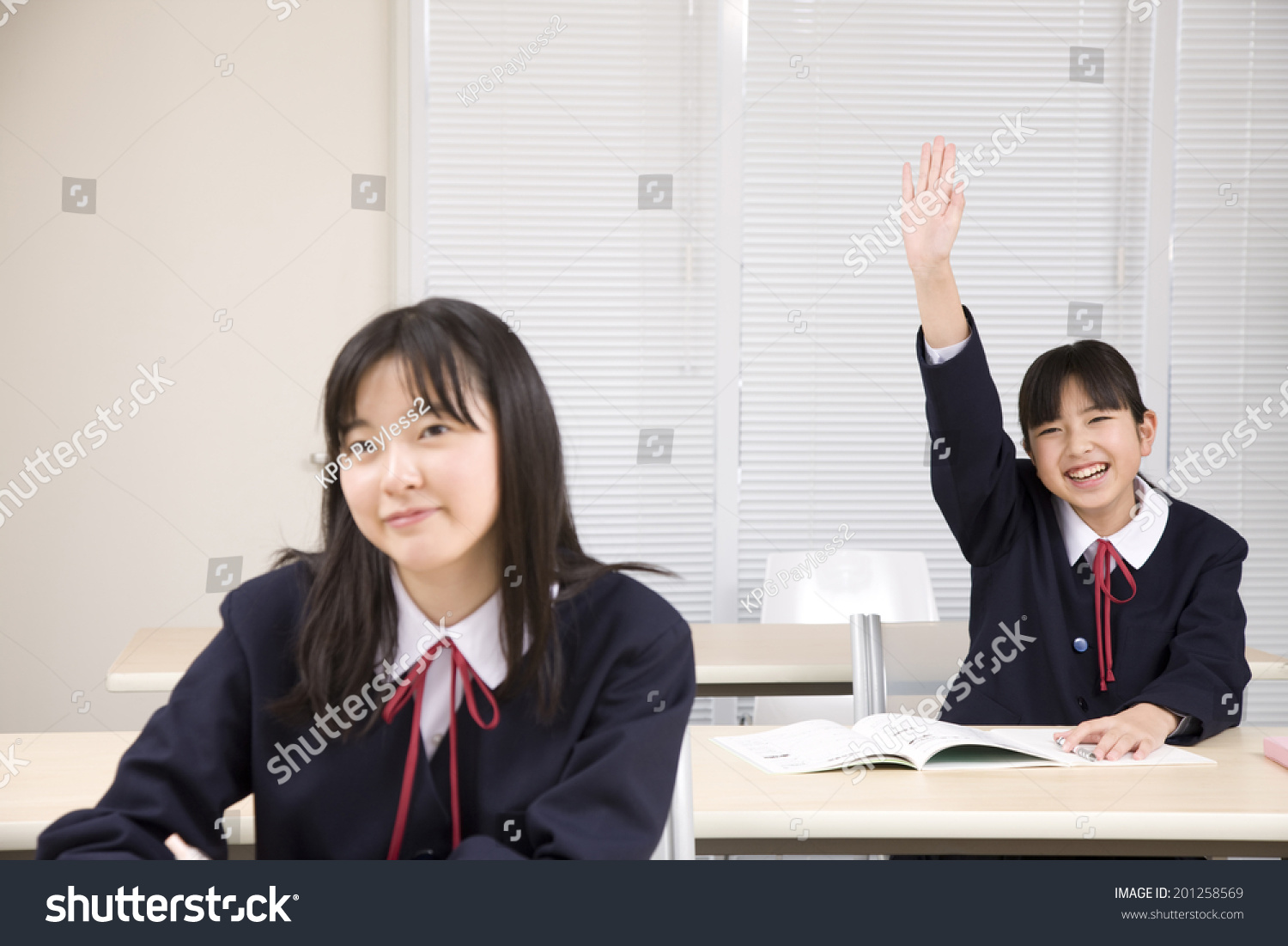 A middle school girl raising her hand