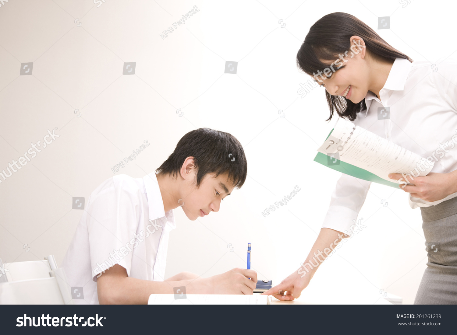 A middle school boy learning from a teacher at an institute