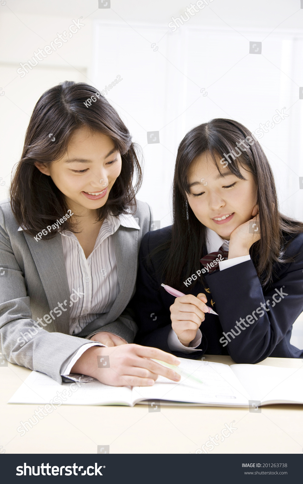 A middle school girl learning from a teacher at an institute