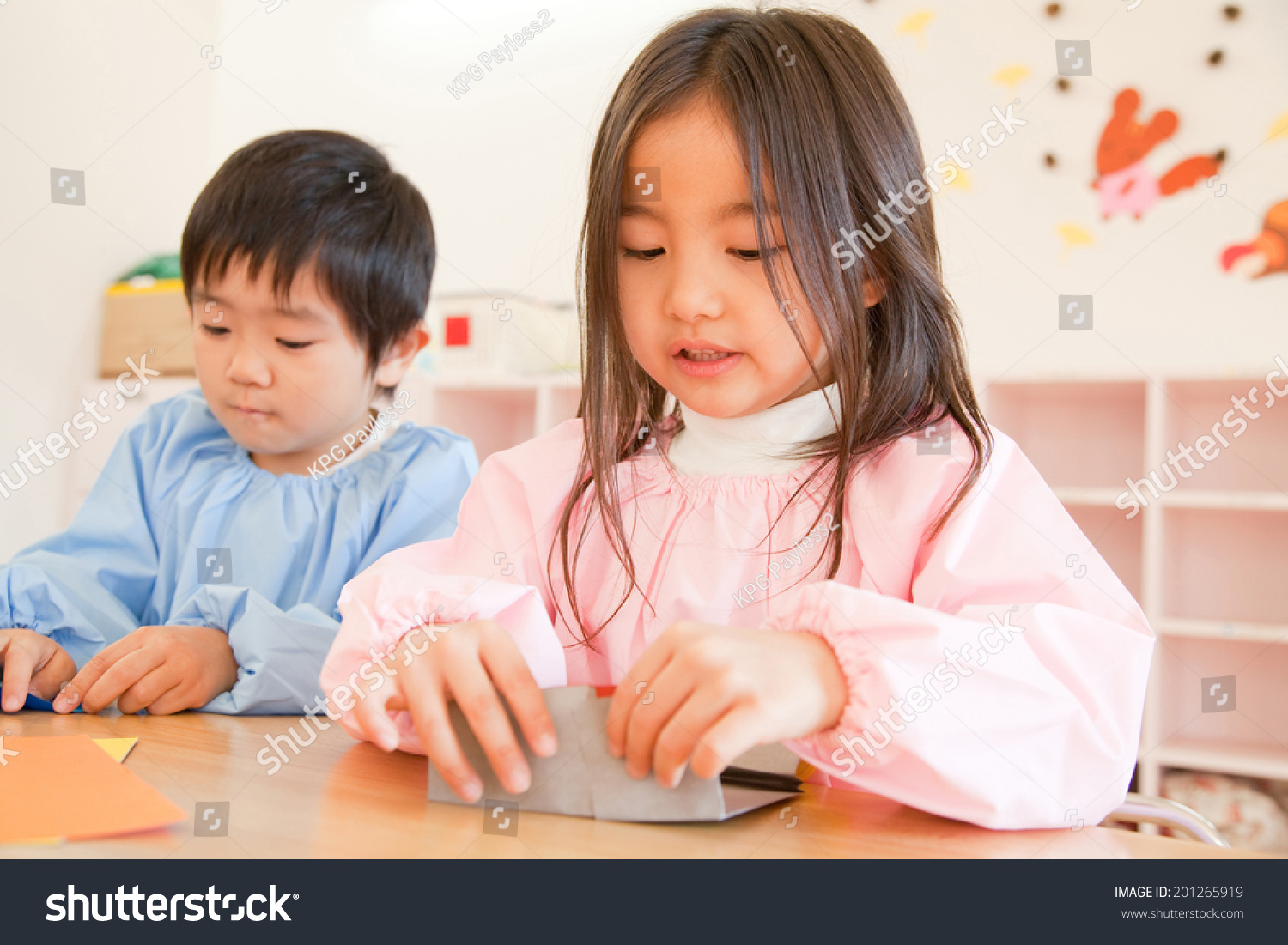 Kindergartener making a folded-paper