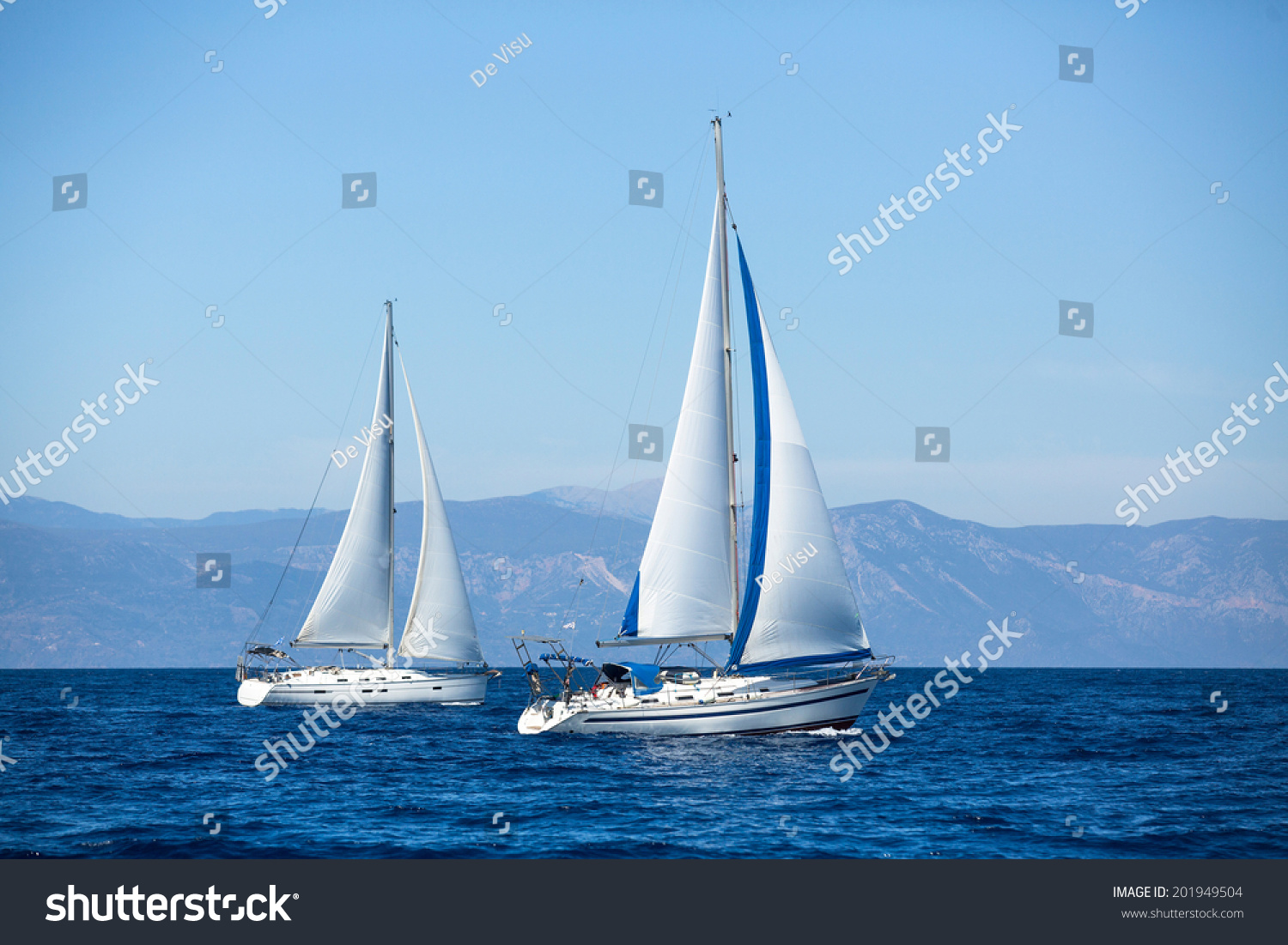 Group of sail yachts in regatta near a coast.