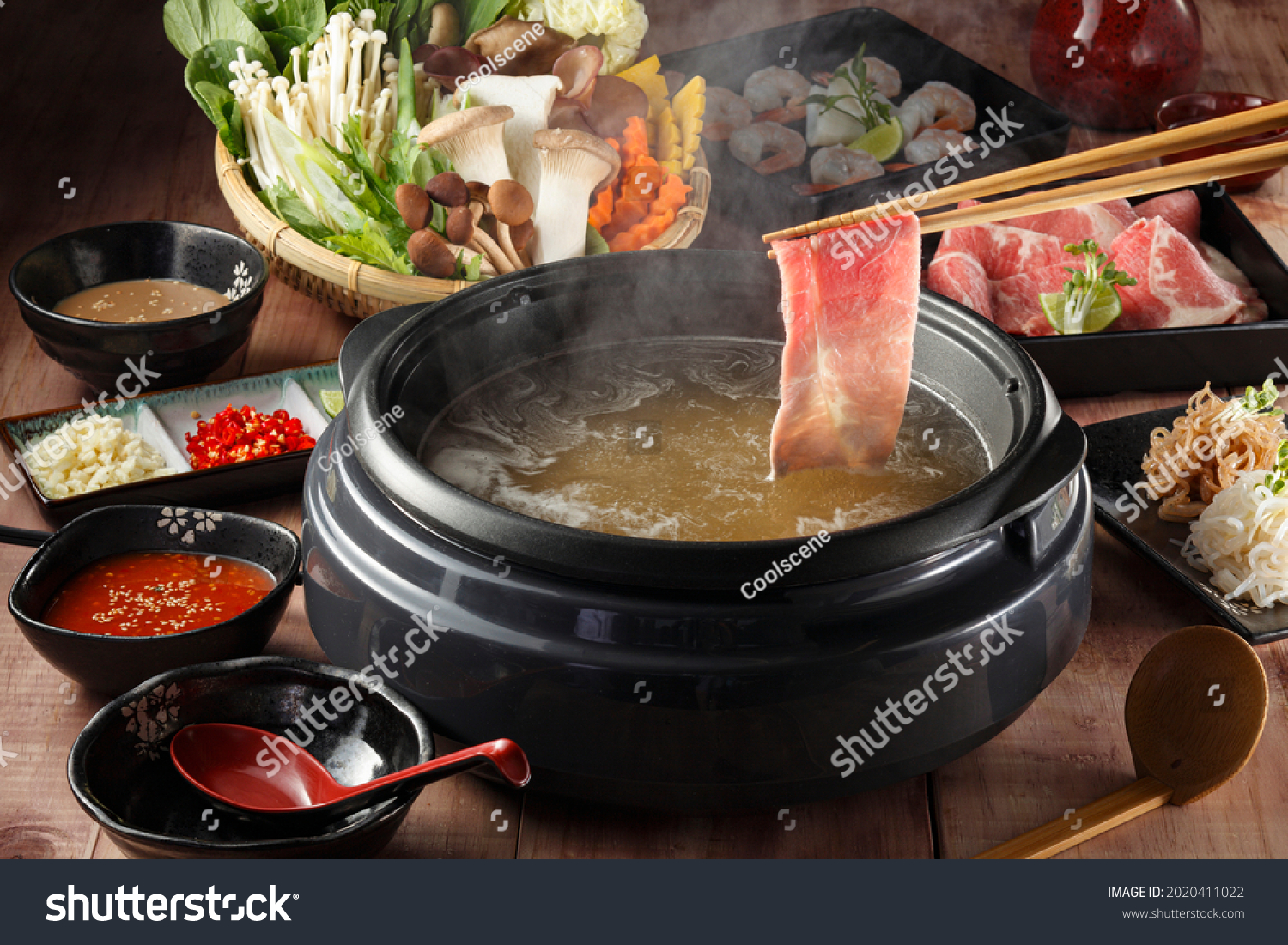 Chopstic holding beef shabushabu or sukiyaki. Beef slice on top of hot