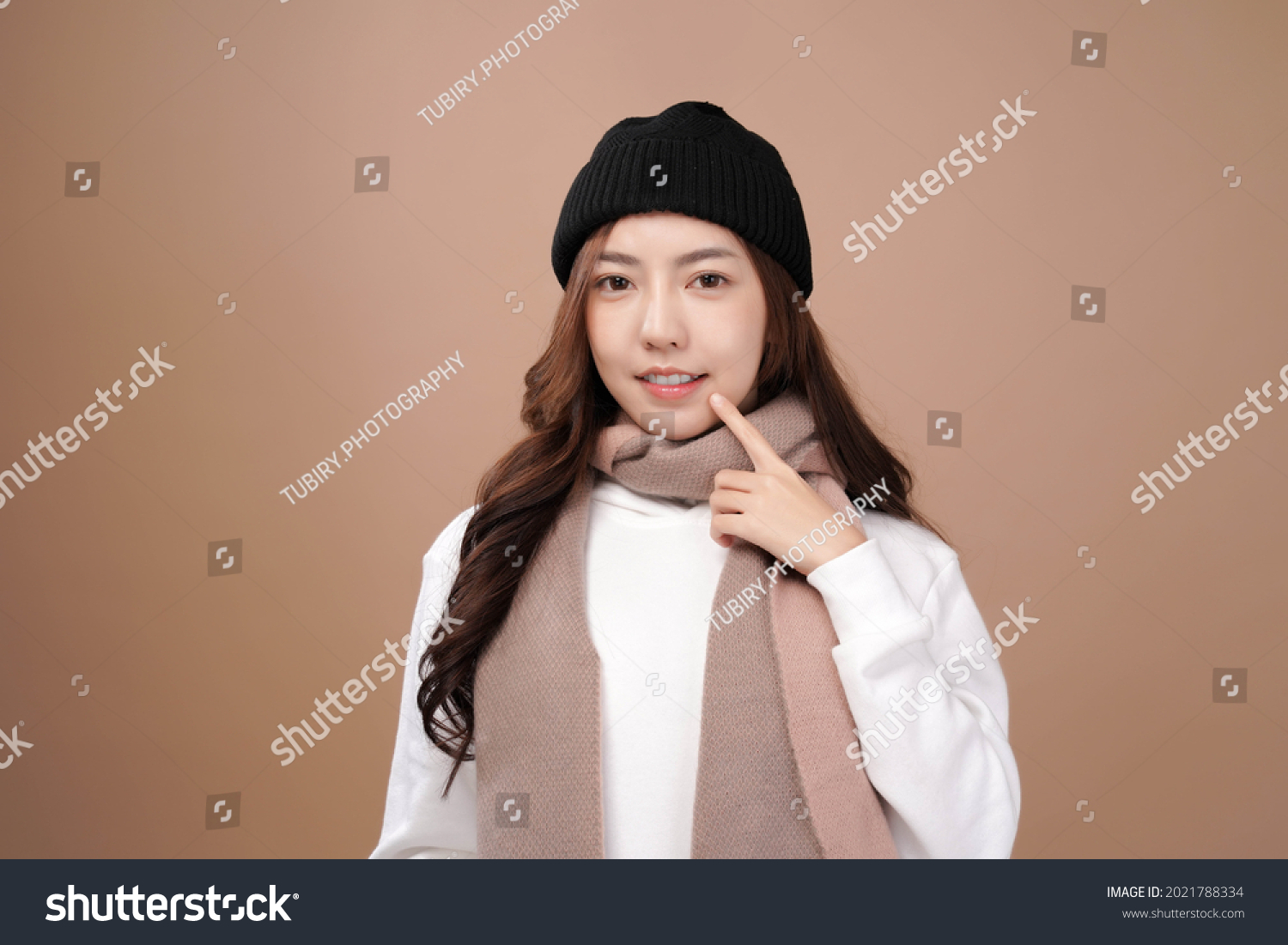 Asian woman with winter outfit wear pink scarf  Mocha brown background