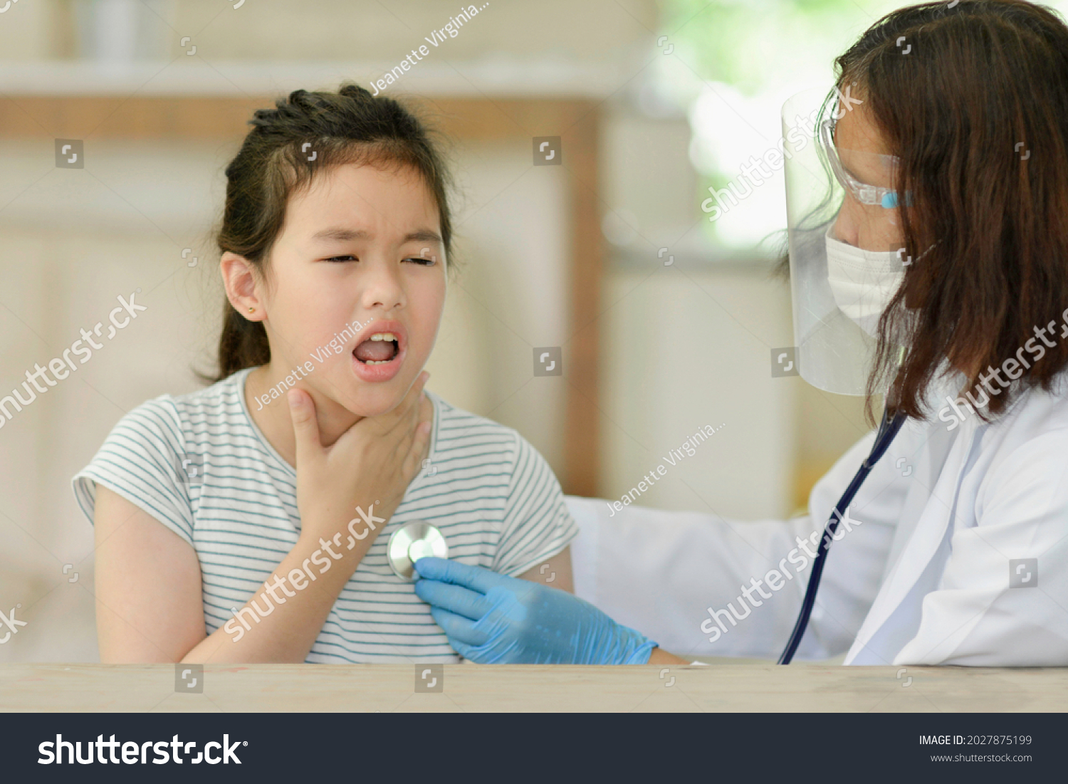 Asian child doing medical check up.Sick kid with doctor in clinic.Pediatrician examining boy's lungs with stethoscope.Health care for young student.Girl coughing.