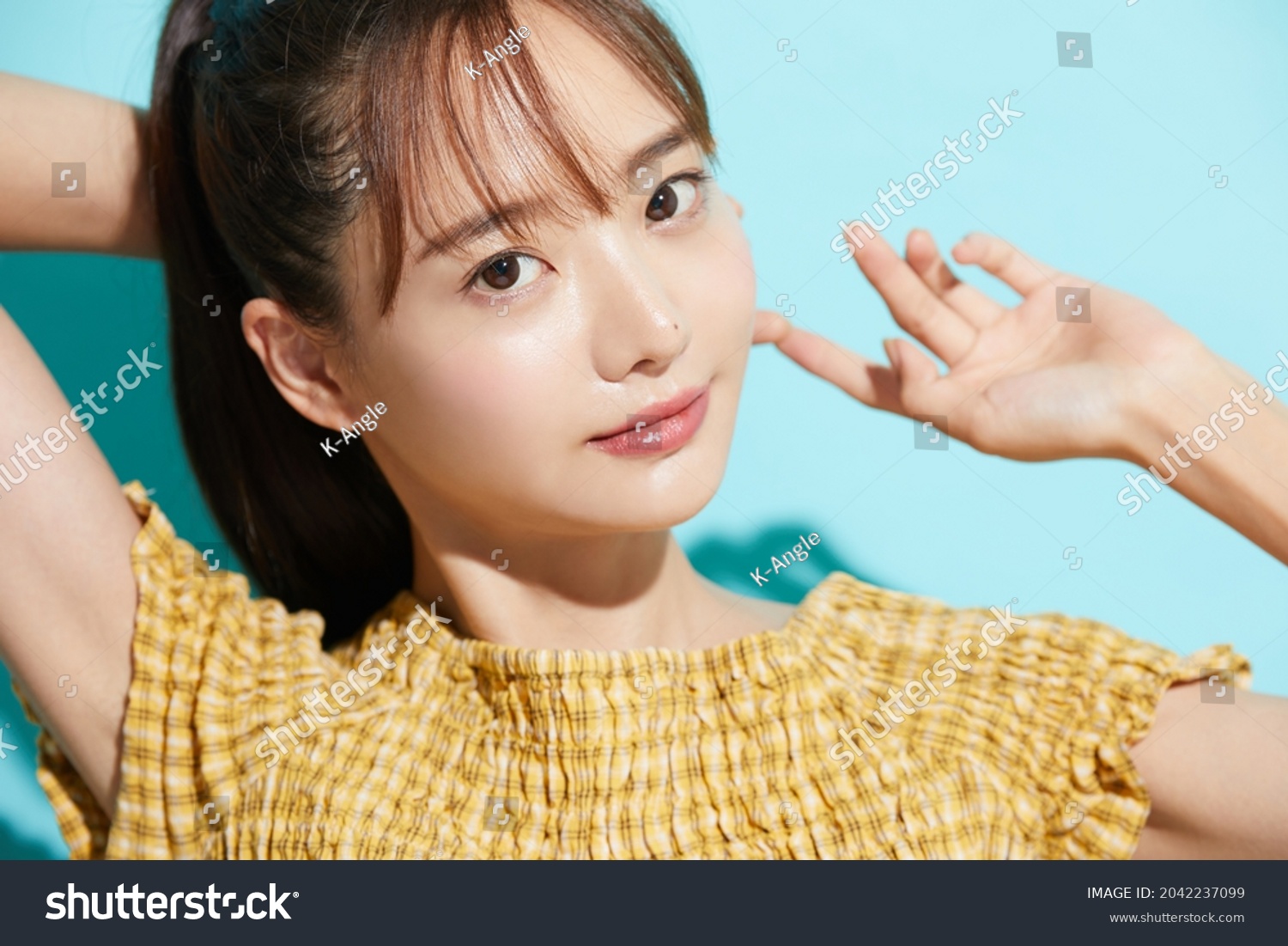 Refreshing beauty portrait of a young Asian woman on a blue background