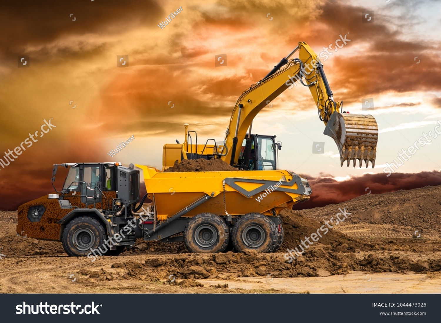 excavator working on construction site with dramatic clouds on sky