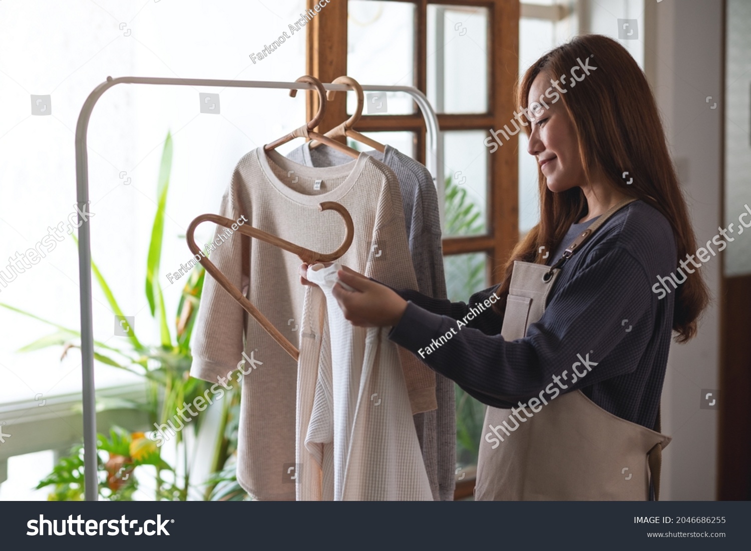 A housewife doing laundry  washing and hanging shirts on clothesline at home