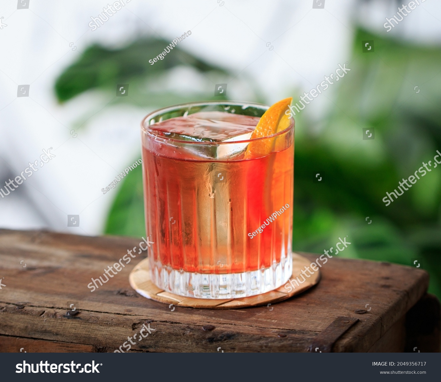 Classic Negroni Aperitivo Cocktail with italian red bitter liqueur and big clear ice cube