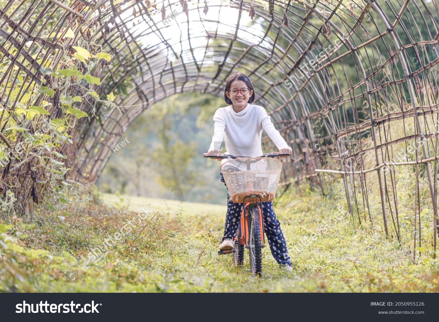 Smile Teenage girl with glasses on a bike in summer park outdoors