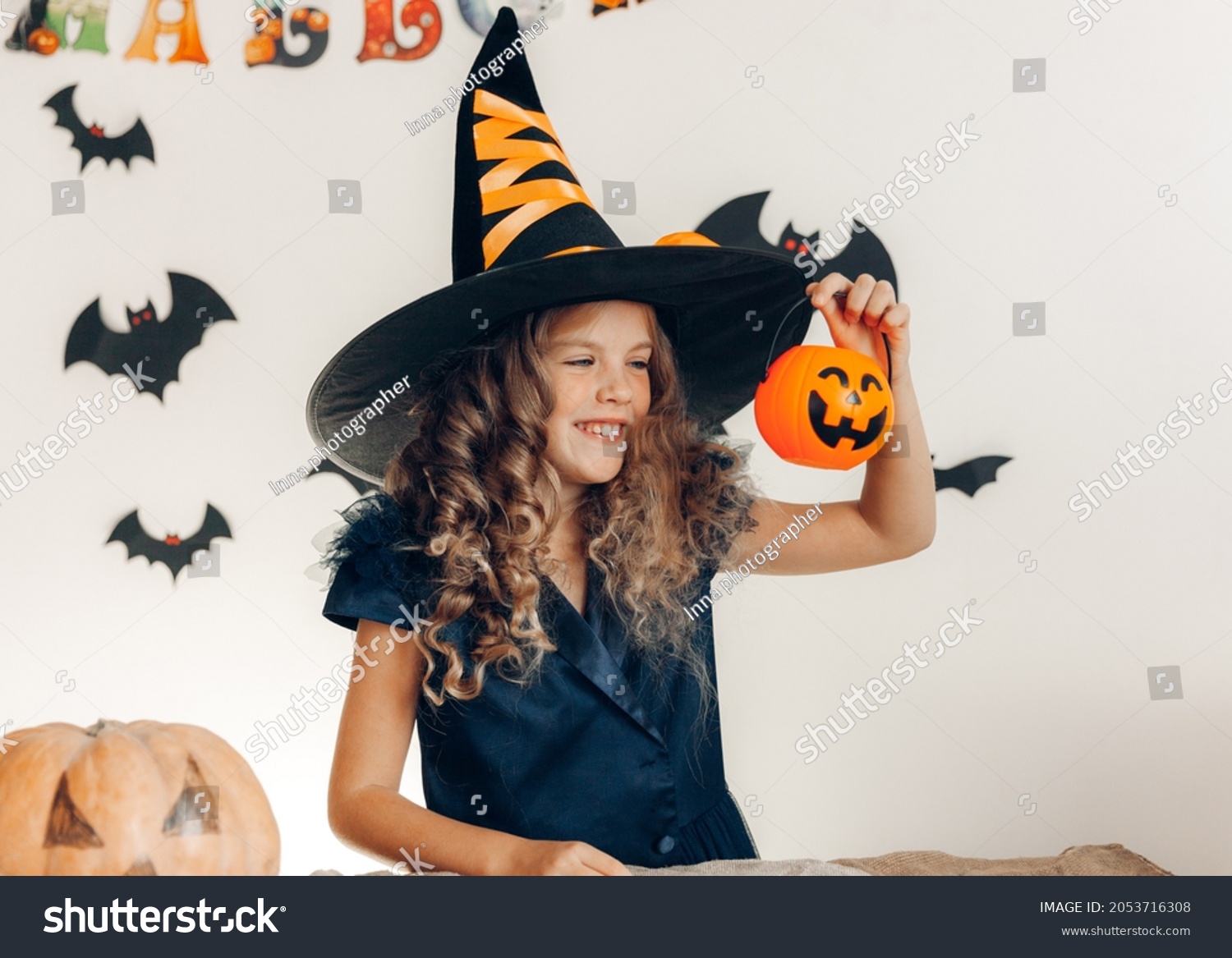 little girl dressed as a witch with a pumpkin. halloween. pumpkin for halloween