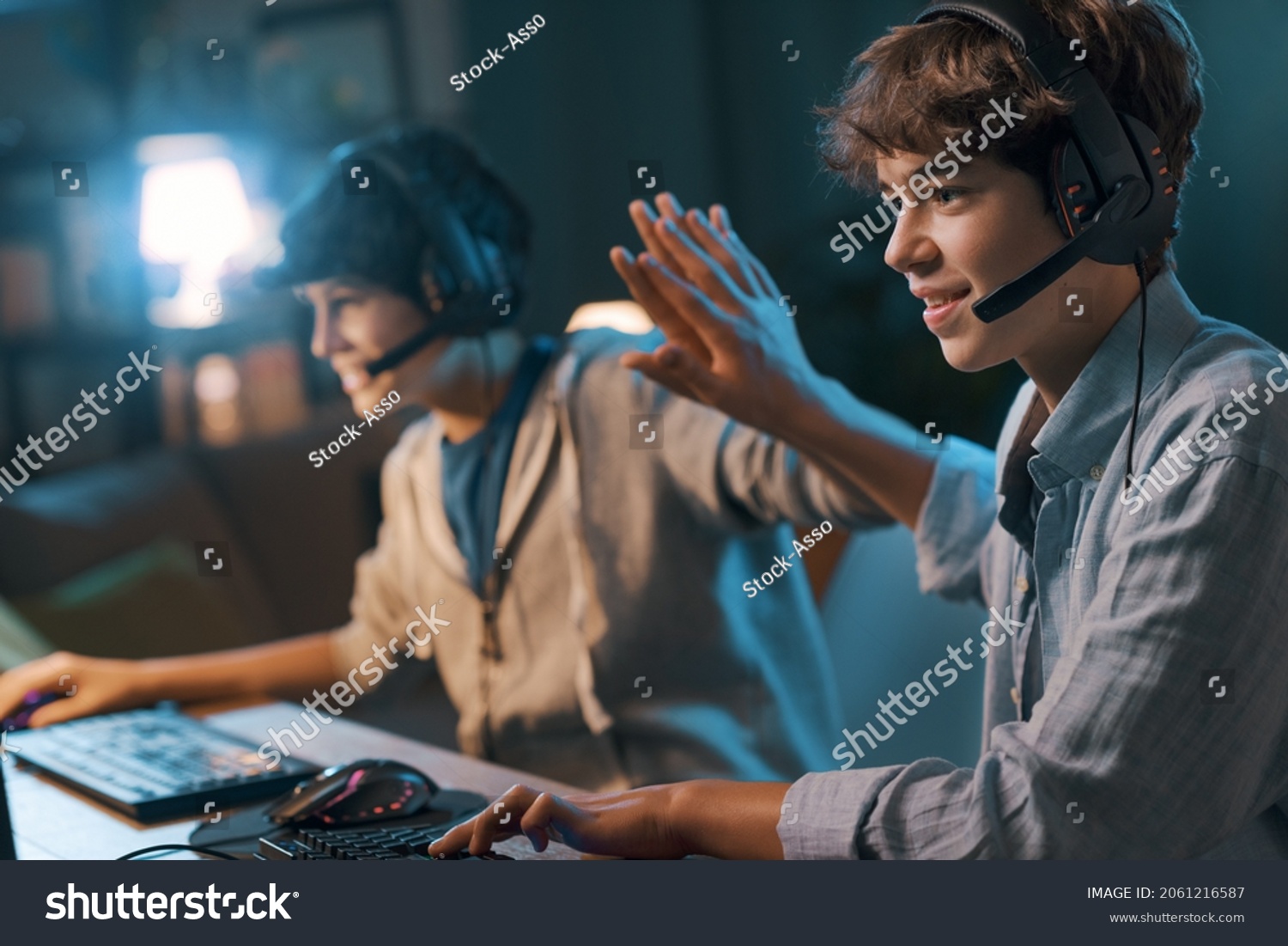 Cheerful friends playing online video games together and winning  they give a high five