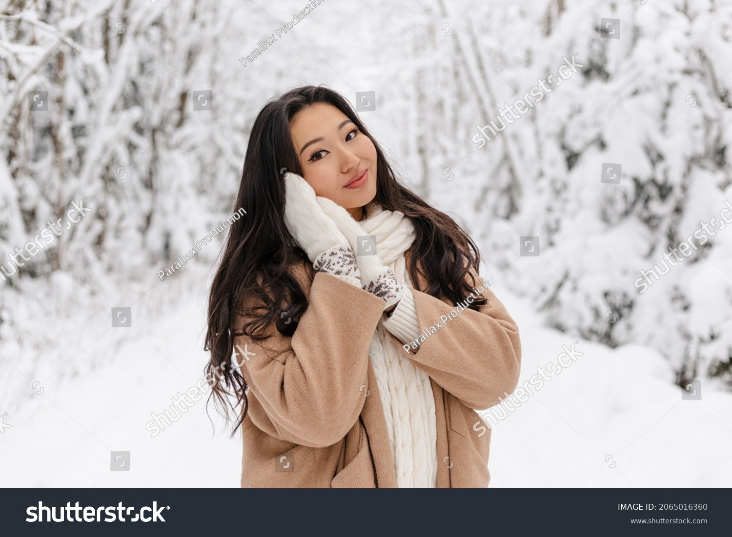 Cute Asian Girl Standing Smiling in WInter Forest. Snowy Winter Day. Lovely Girl