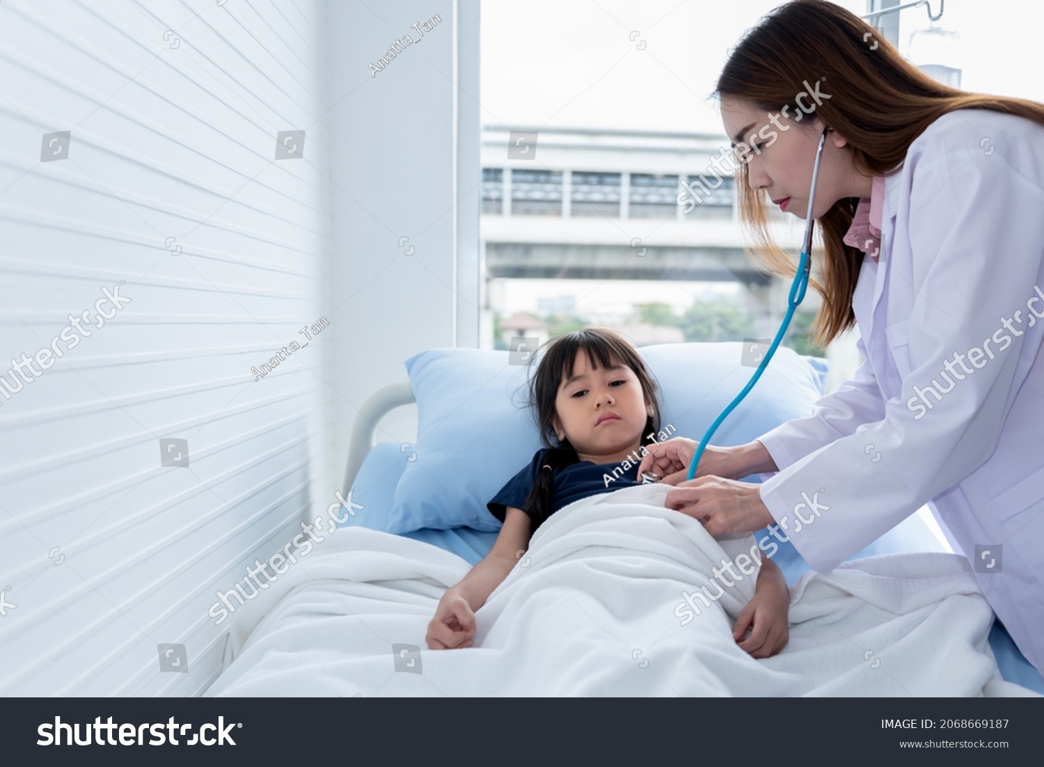 Asian woman doctor is using a stethoscope Listen to heart rate Of a 6 year old patient who came to treat the flu which is pandemic to health care and children concept.