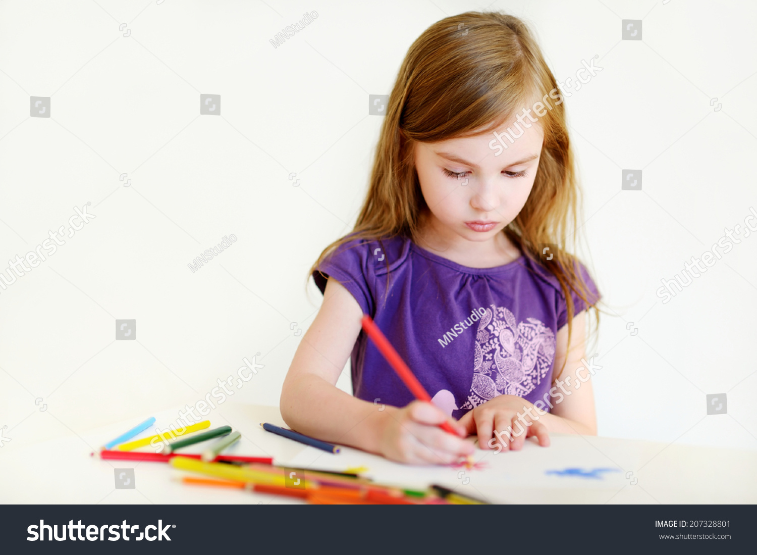 cute preschooler girl drawing a picture with colorful pencils