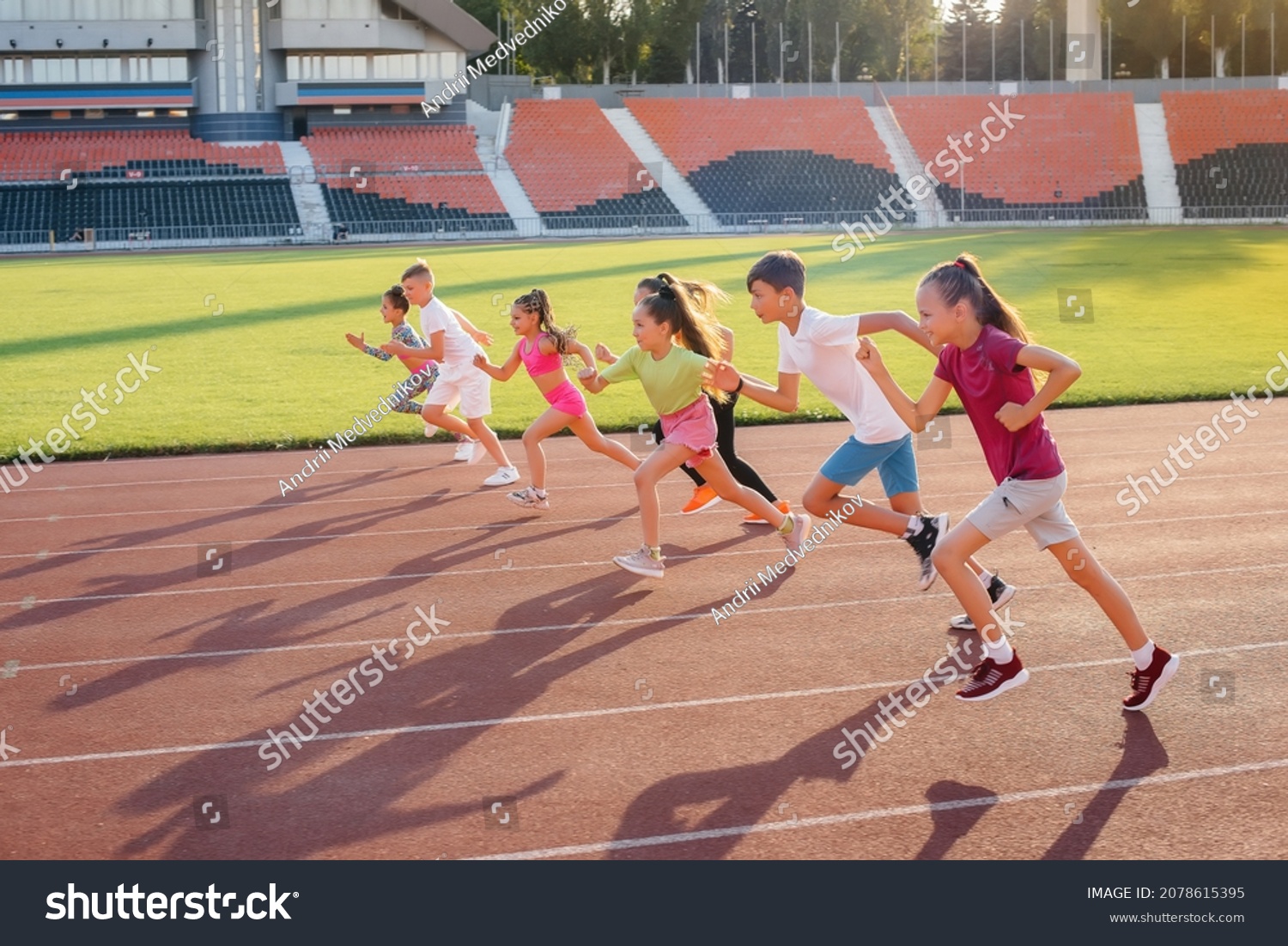 A large group of children boys and girls run and play sports at the