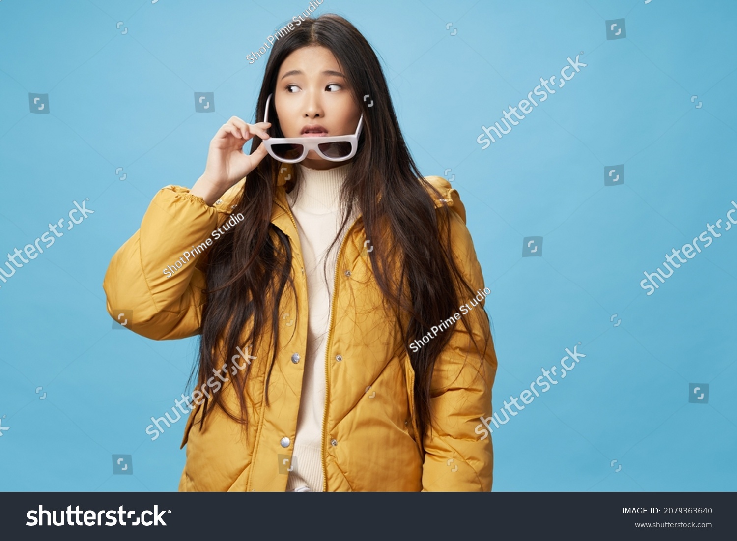 fashionable woman in winter jacket glasses modern style blue background