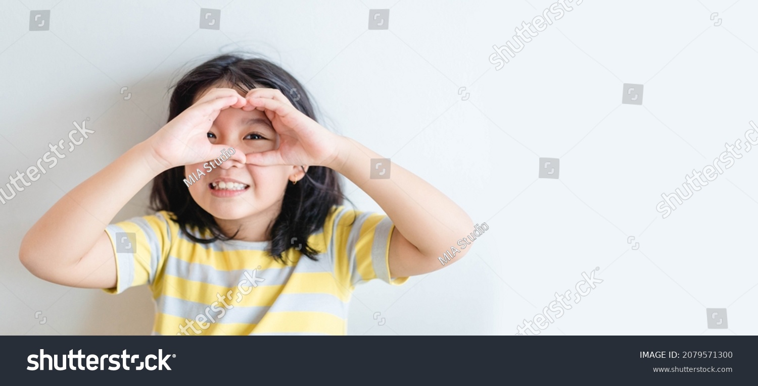 Healthy eyes and vision.Portrait happy asian kid child holding heart shaped hands on eyes.Smiling Girl With Healthy Skin Showing Love Sign. Eye care.Carotene vitamin.Focus  optician doctor  optical.