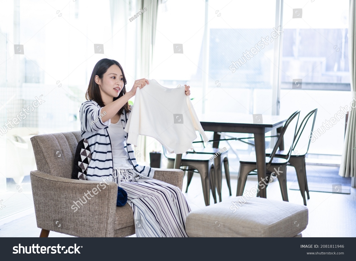 Young woman folding laundry at home