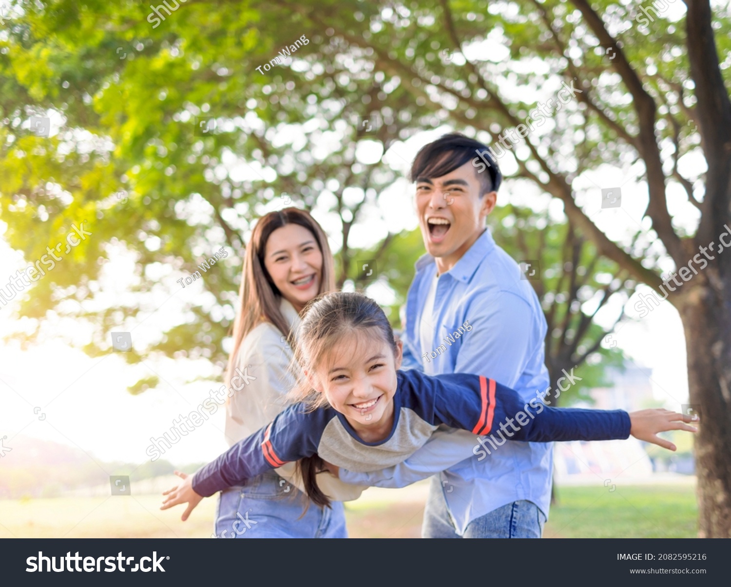 Happy Family with daughter playing together in the park