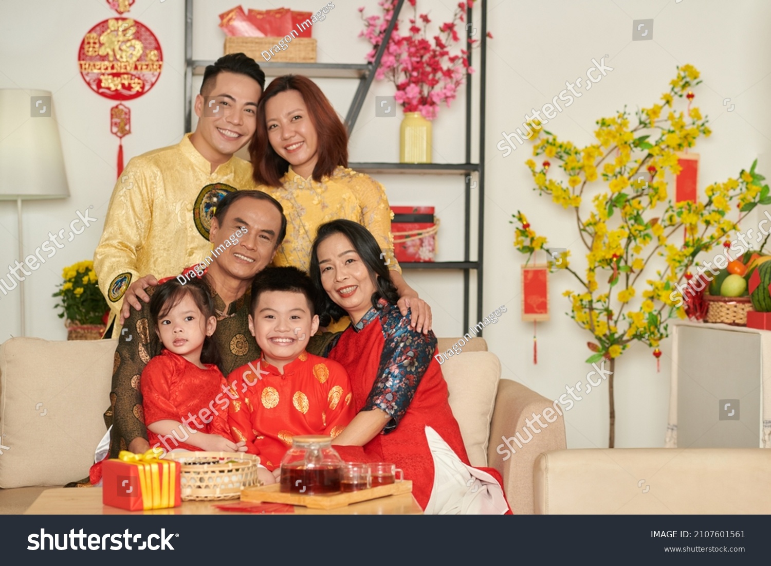 Hugging grandparents  parents and children in traditional ao dai dresses hugging and smiling at camera