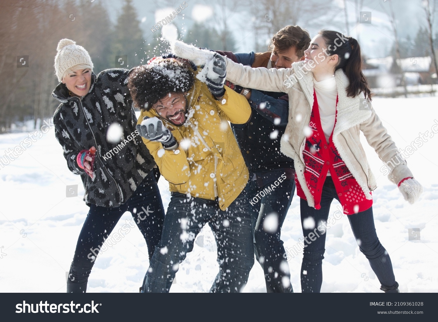 Playful friends enjoying snowball fight