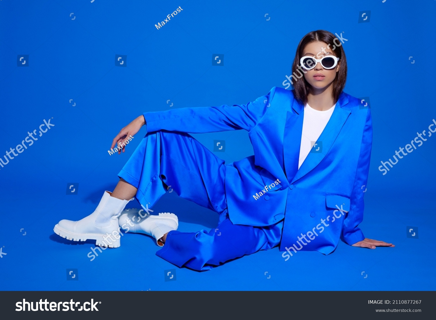 Fashion asian female model in blue suit  white boots and sunglasses. Asian fashion