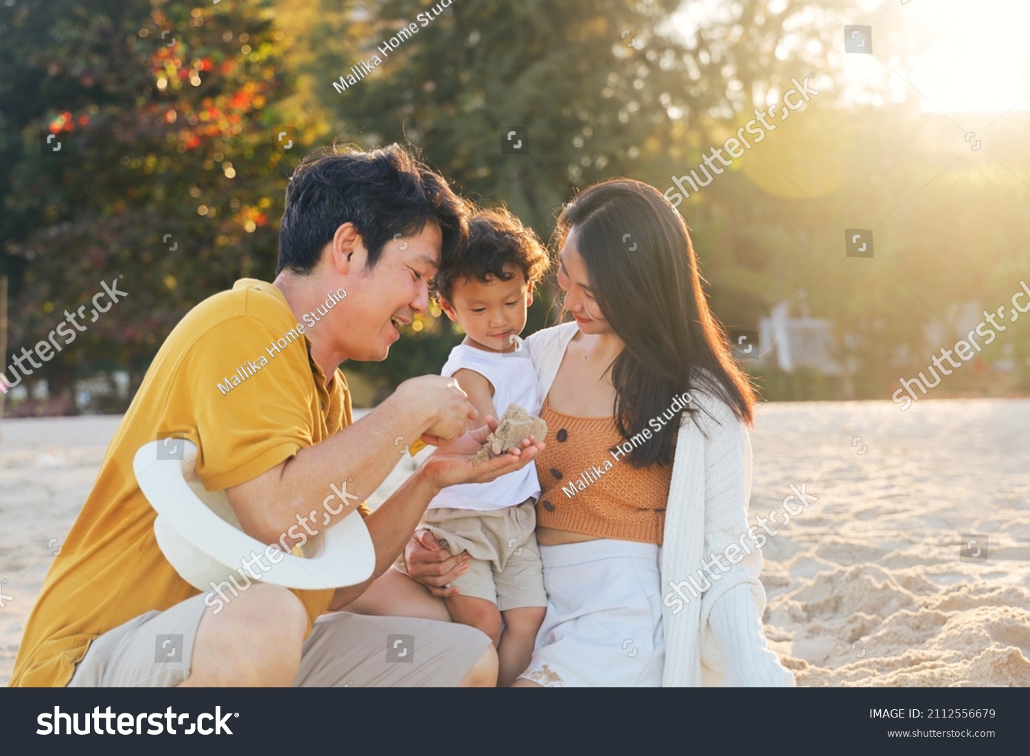 Cheerful Asian family travel at the beach.cute Asian boy playing with parents.