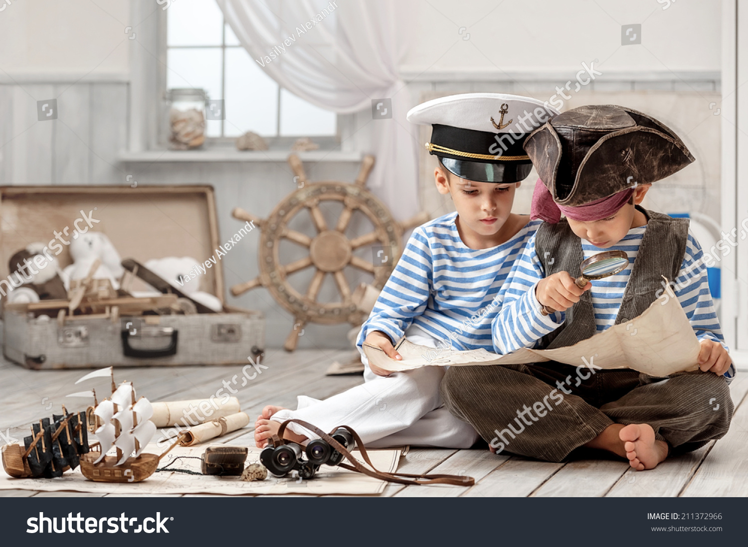 Two boys  a pirate captain  read travel map in her room
