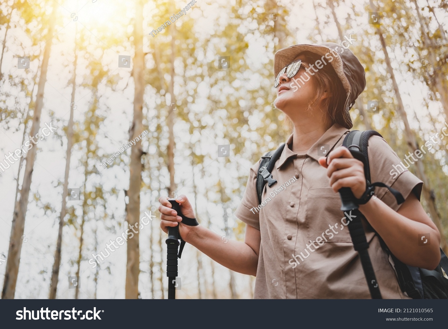 Asian woman hiking trail and trekking in the forest alone. Travel and outdoor activity. Relax and recreation in autumn holiday.