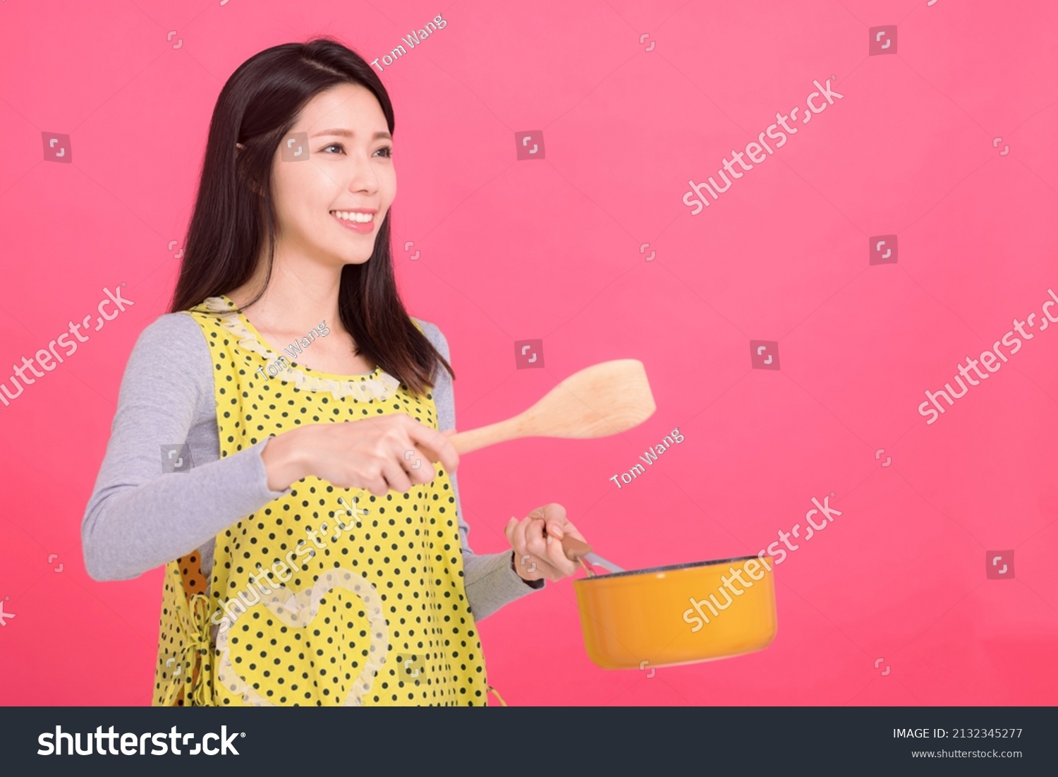 Happy young woman housewife Wearing Kitchen Apron while cooking